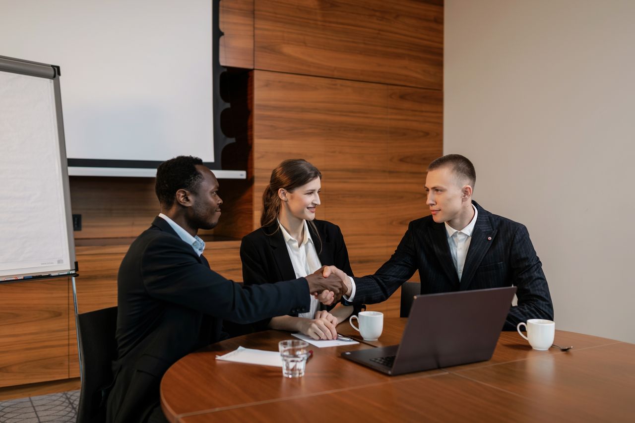 Professionals shaking hands at a business meeting, showcasing teamwork and collaboration.